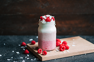 Raspberry Ombre Kefir Smoothie Topped With Raspberries and Coconut Flakes