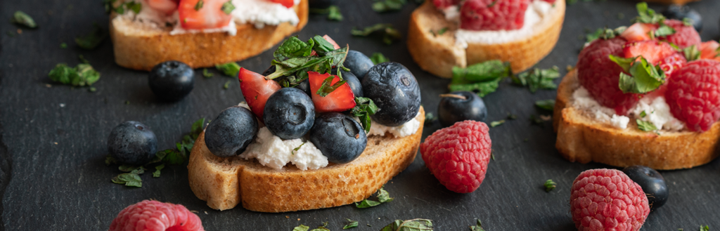 crostinis topped with farmer's cheese, fresh berries, and honey